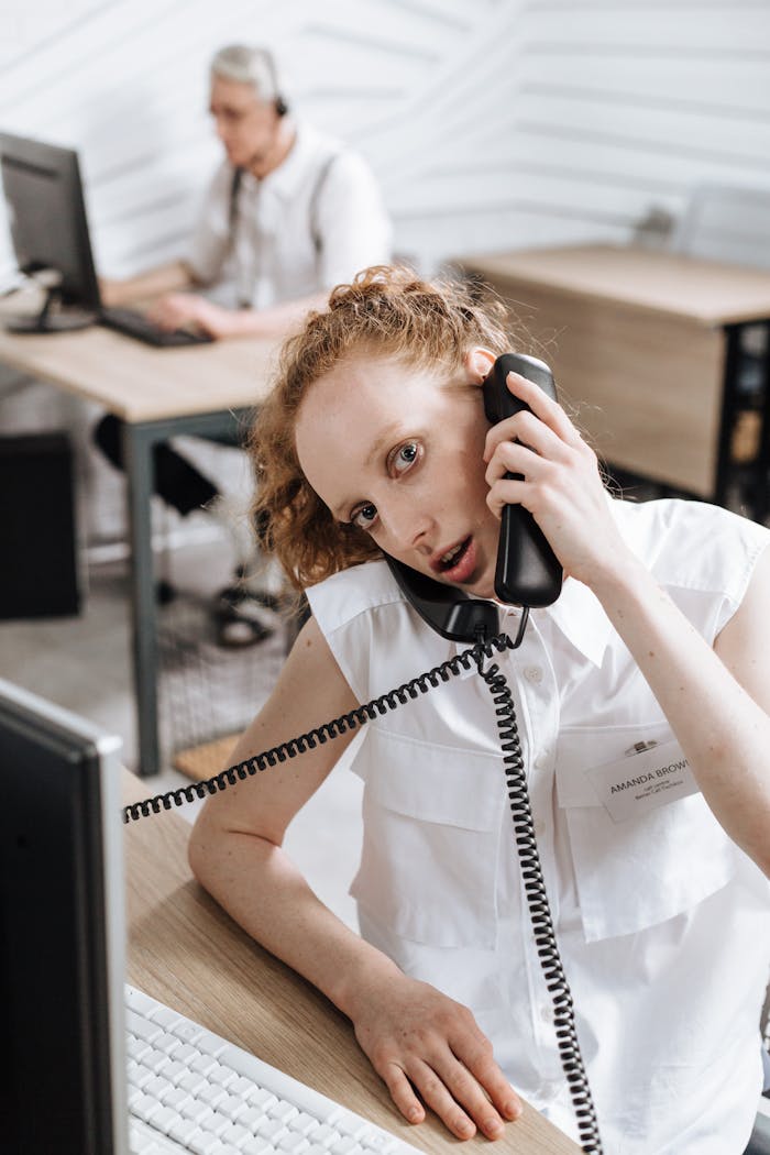 Caucasian call center agent attending calls in a modern office setting.